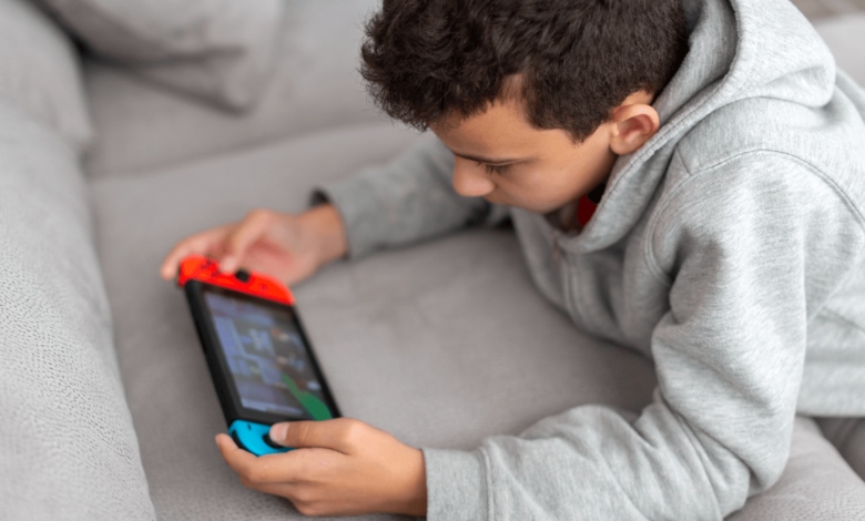 Child playing Nintendo Switch on the couch